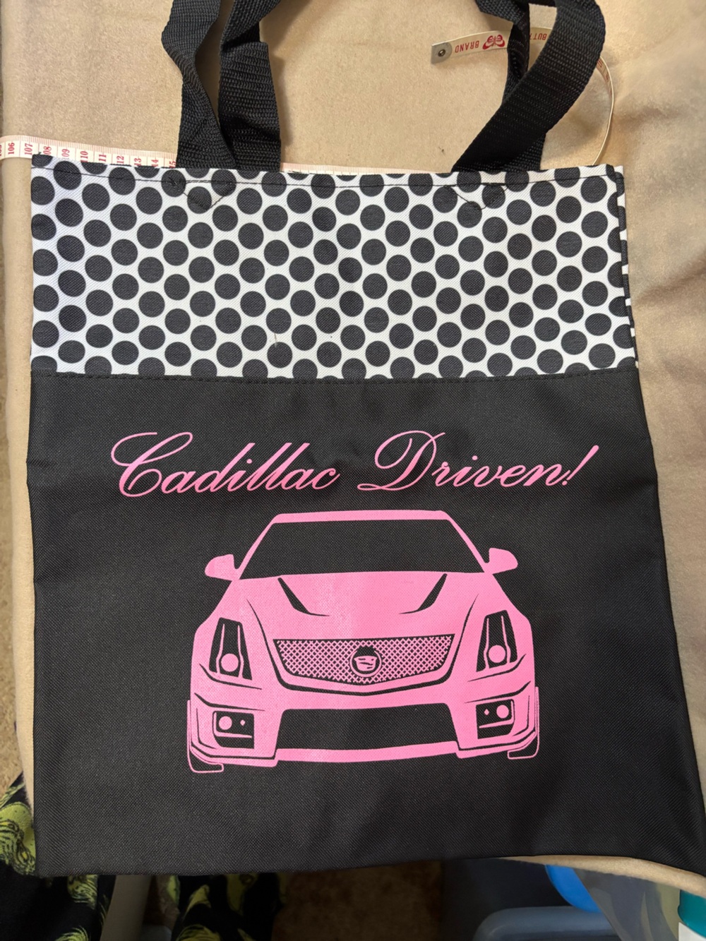 Tote bag with a pink graphic of a Cadillac front end and Cadillac Driven